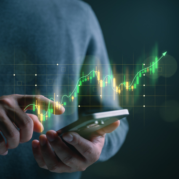 Trader or investor using smartphone with glowing stock market chart and upward trend, symbolizing digital trading, investment growth, fintech analytics, real-time data, and financial decision making.